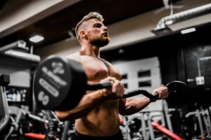 bodybuilder performing barbell curls during a workout session in the gym