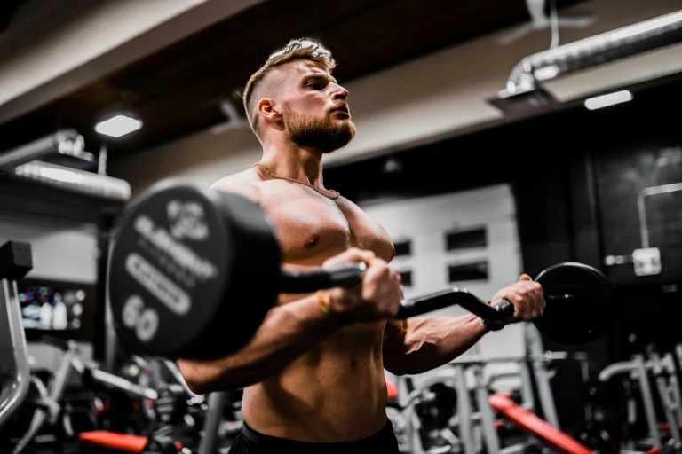 bodybuilder performing barbell curls during a workout session in the gym