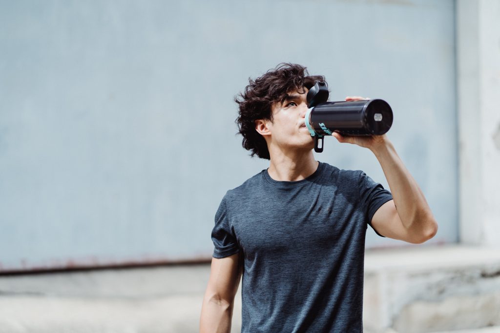 man-drinking-liquid-from-a-bottle-intra-workout