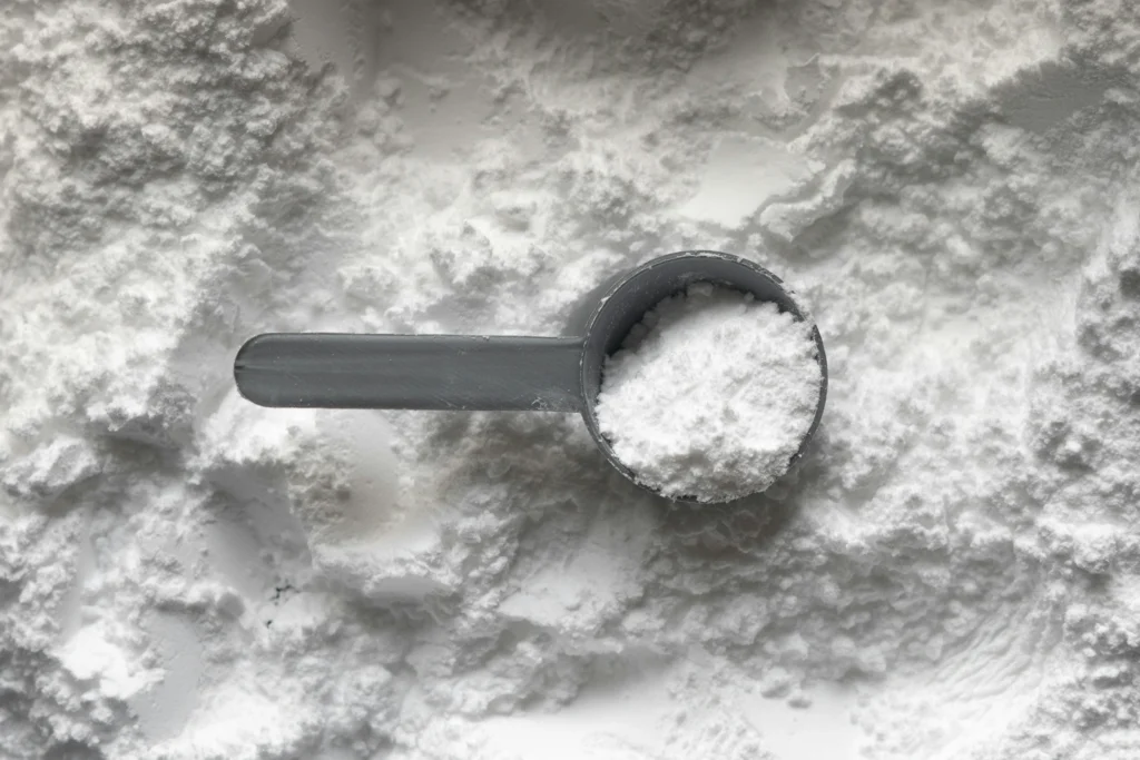 Creatine monohydrate powder on a measuring scoop