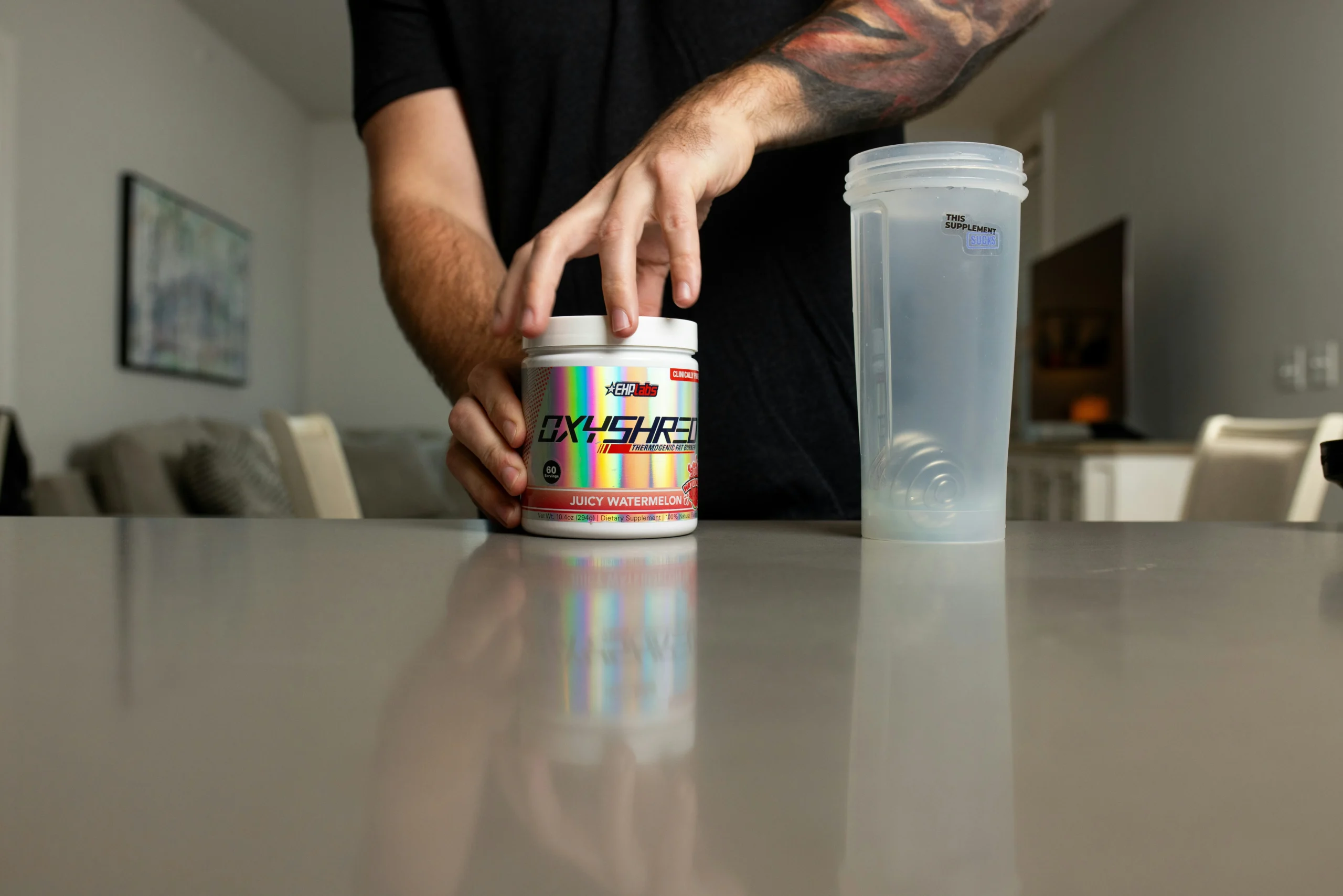 Pre-workout powder and shaker bottle on a bench