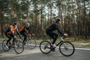 Three cyclists riding bikes through a scenic forest on a sunny day burning active calories