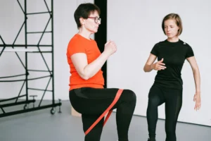 women muscle mass – personal trainer guiding woman through resistance training exercise