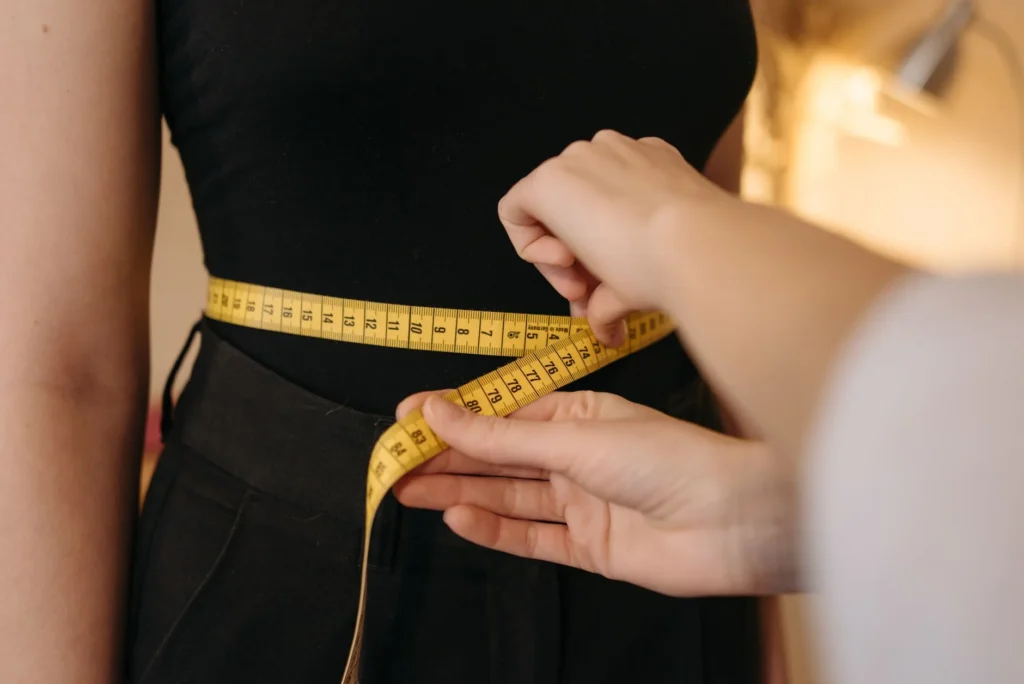 body measurement chart – woman being measured with tape measure for clothing size and health tracking