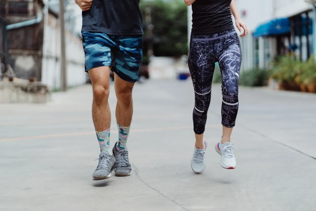 running calories – fit couple jogging outdoors in activewear for calorie burn