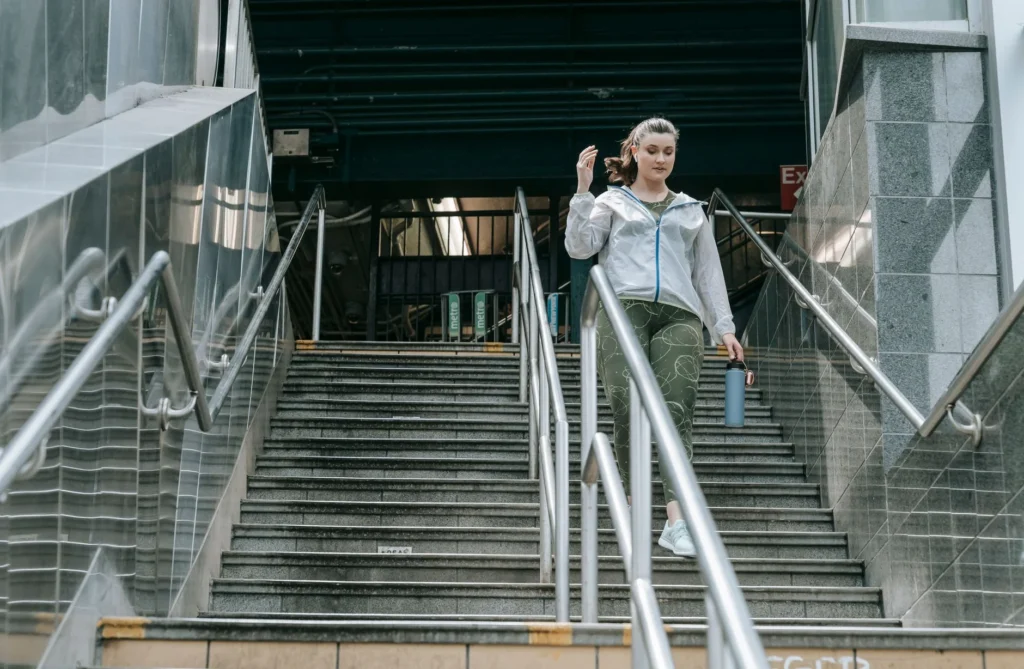 calories walking – woman in sportswear descending stairs outdoors for fitness exercise