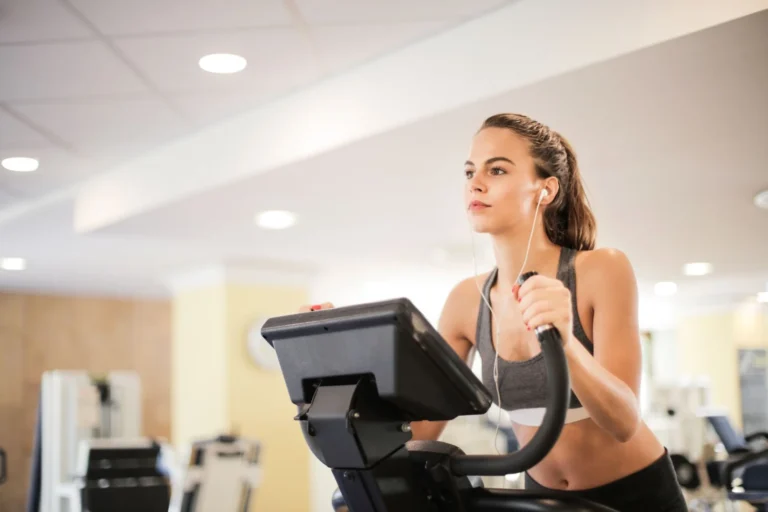 Person using an elliptical machine at the gym for a cardio workout