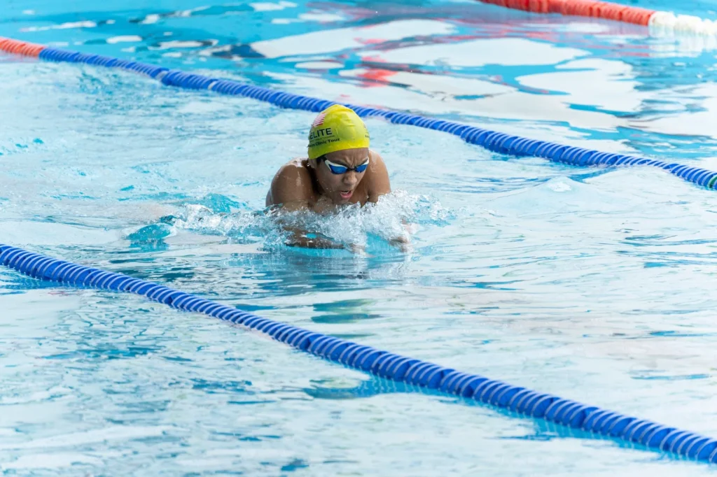 breaststroke swimming – swimmer doing breaststroke in a pool for calorie burn and fitness