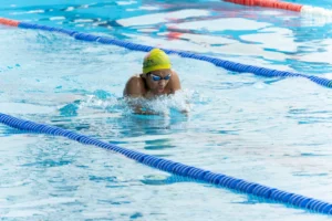 breaststroke swimming – swimmer doing breaststroke in a pool for calorie burn and fitness