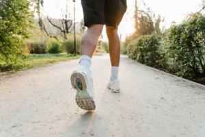Jogger running on a park path at sunset during outdoor fitness exercise