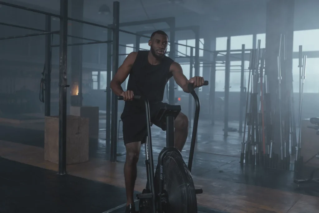 calories burn exercising – man working out on elliptical machine in gym for daily calorie burn