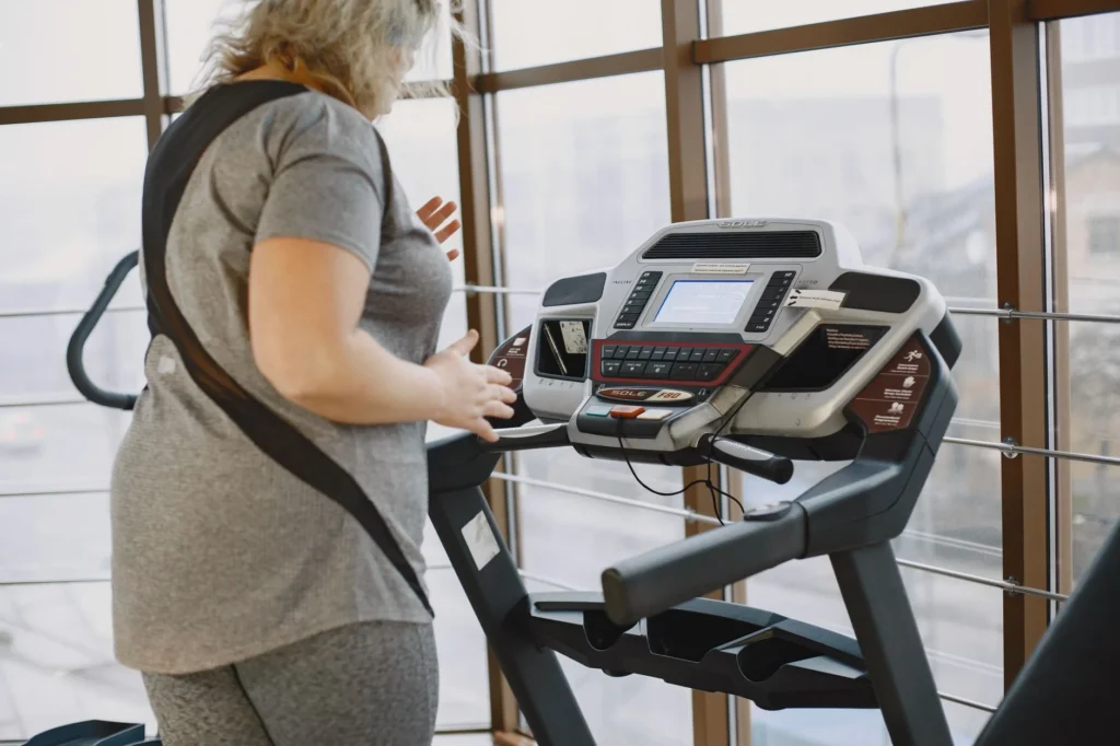 treadmill incline workout – person walking on incline treadmill for calorie burn