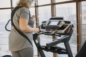 treadmill incline workout – person walking on incline treadmill for calorie burn