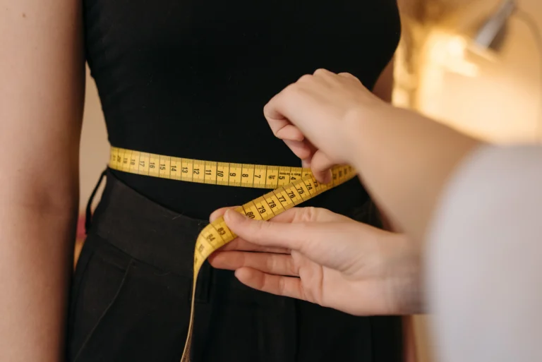 waist measurement – person using a tape measure around the waist for health tracking