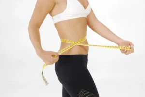 where is your waist – fit woman measuring her waist with tape measure showing correct measurement spot