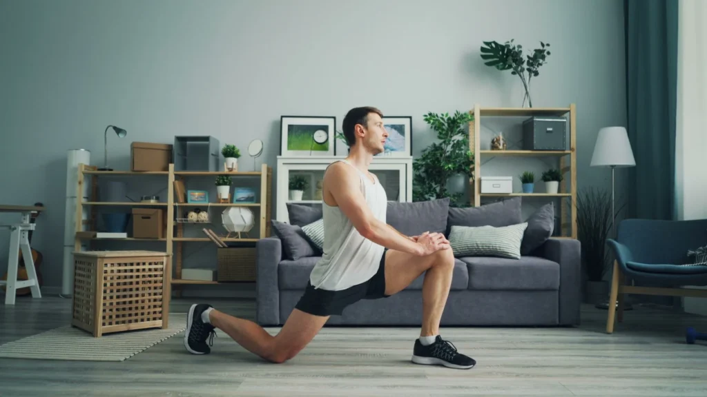 Man doing bodyweight lunges at home, part of a 30 day workout plan for beginners