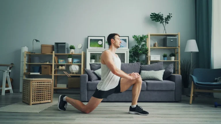 Man doing bodyweight lunges at home, part of a 30 day workout plan for beginners