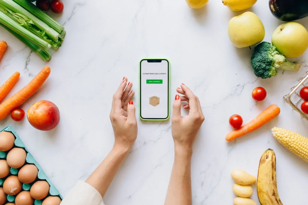 AI meal plan generator app on smartphone with fresh groceries for a personalised grocery list