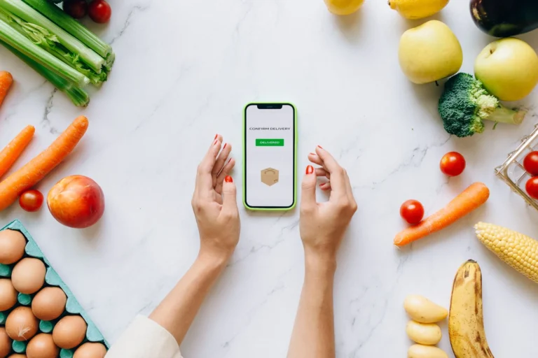 AI meal plan generator app on smartphone with fresh groceries for a personalised grocery list