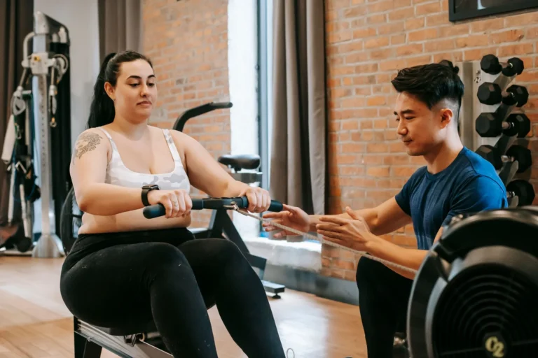 Person rowing on a rowing machine for calories burned fitness workout
