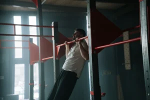 person doing pull-ups – a man performing strict pull-ups on a bar for upper body strength training