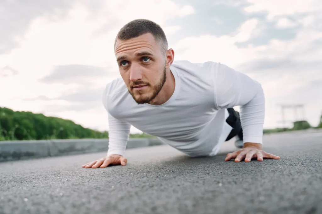push-ups average person – person performing push-ups on a gym mat demonstrating proper exercise form