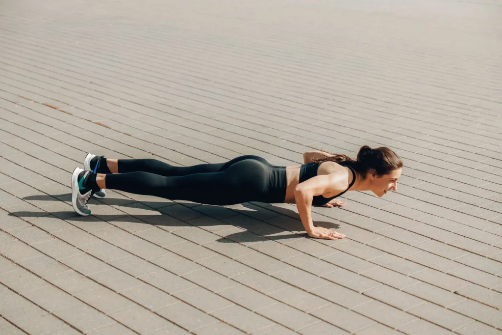 woman push-ups fitness – woman performing push-ups on a gym mat showing proper form and technique