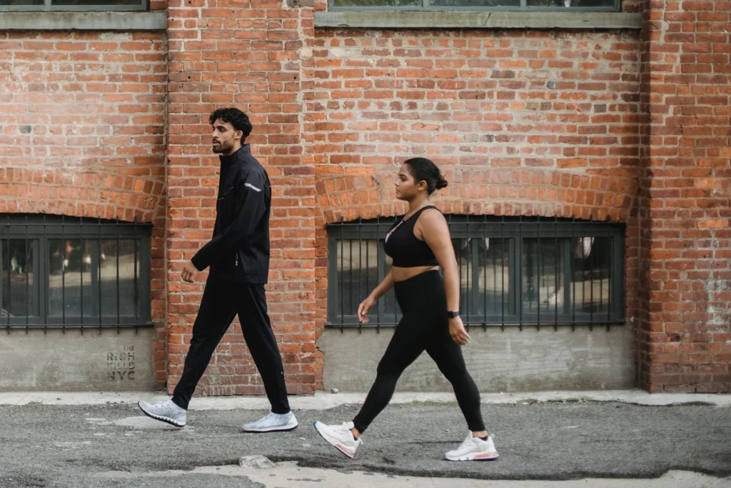 15,000 steps a day – man and woman walking briskly in activewear for fitness