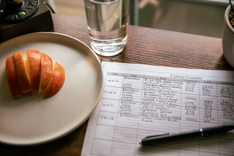 Weight loss tracker printable – calorie counting sheet with pen and apple slices for daily tracking
