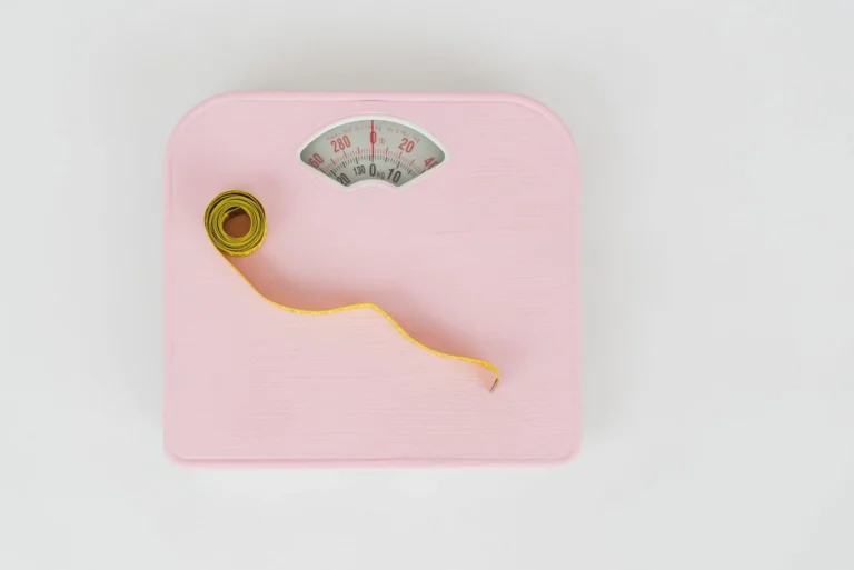 Weight tracker chart – floor scale and measuring tape used to monitor body weight progress