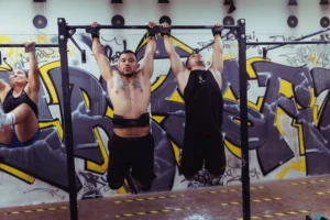 Women exercising on pull-up bars in an urban gym – group workout training session