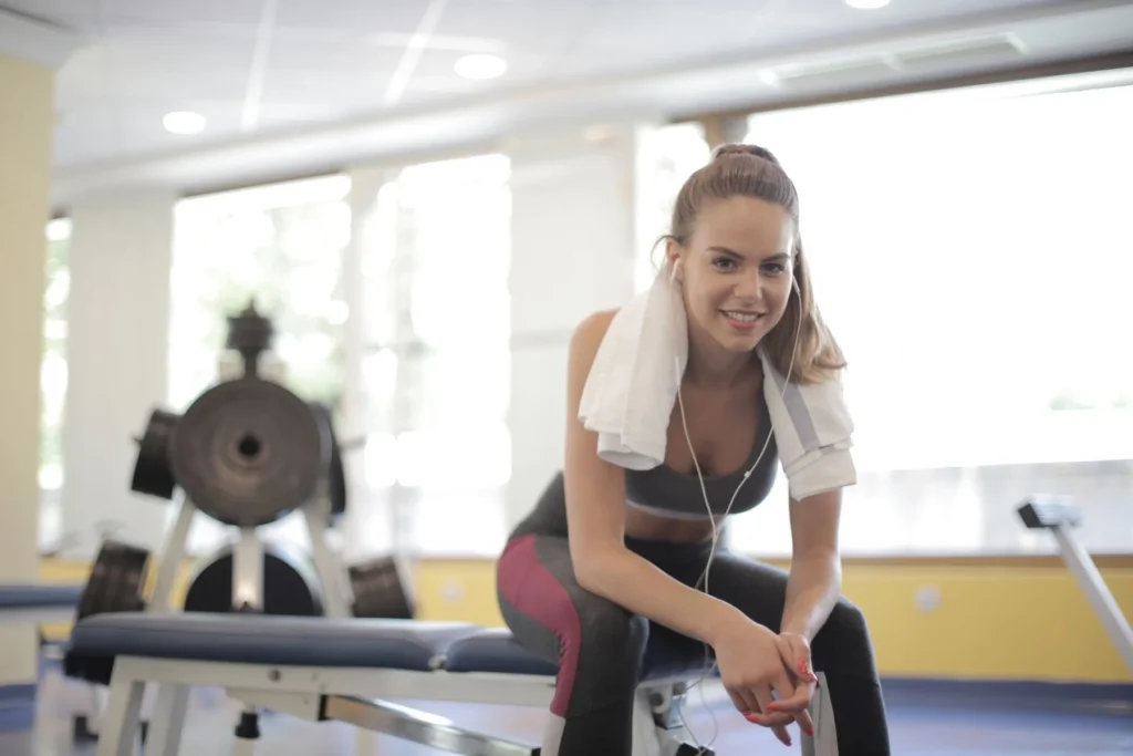 Athletic woman taking a relaxed break on a gym bench during a lighter training week