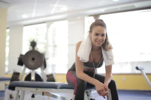 Athletic woman taking a relaxed break on a gym bench during a lighter training week