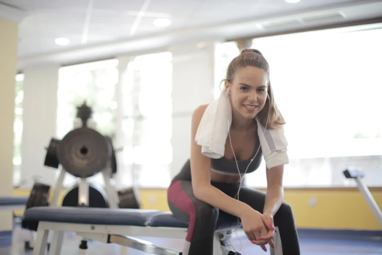 Athletic woman taking a relaxed break on a gym bench during a lighter training week