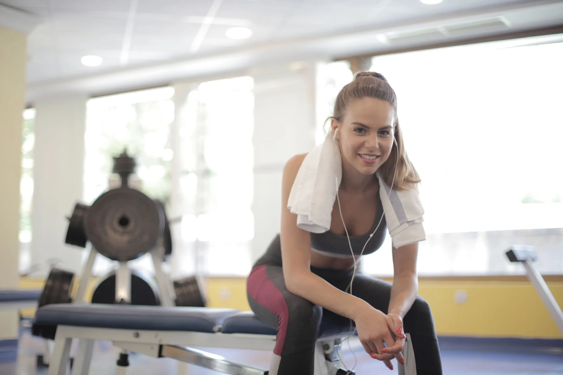 Athletic woman taking a relaxed break on a gym bench during a lighter training week