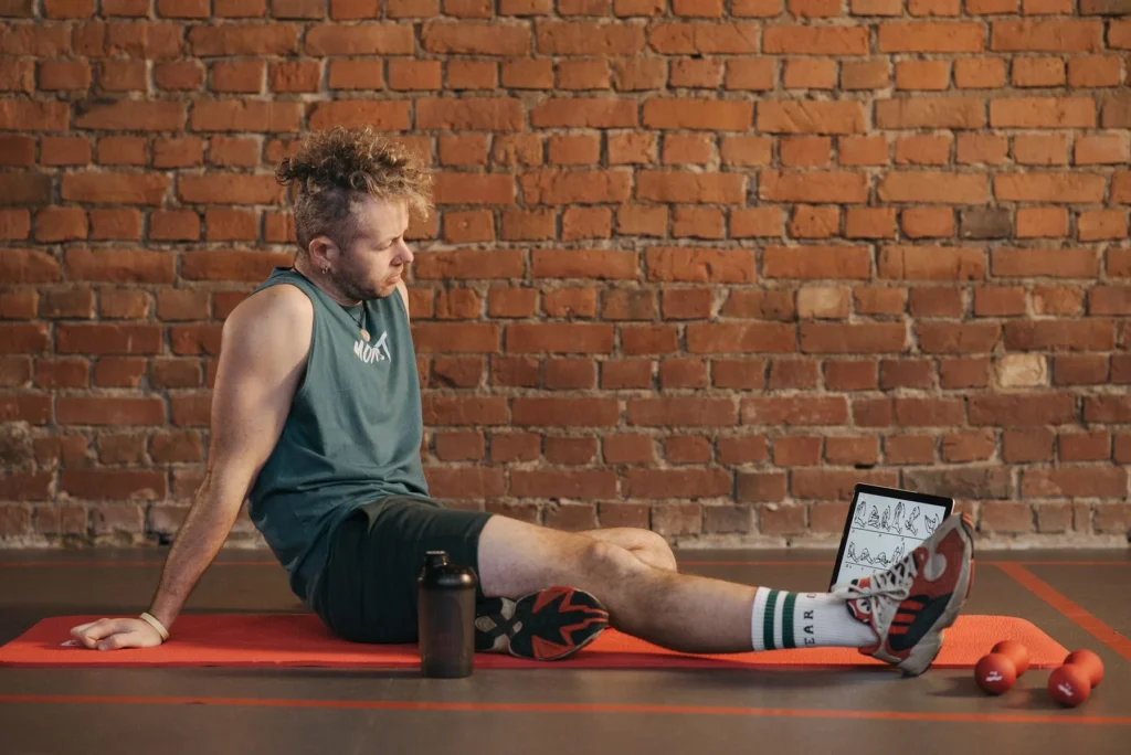 Man resting on a mat in the gym after a workout, illustrating how many rest days a week you actually need for recovery