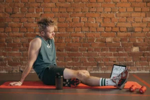 Man resting on a mat in the gym after a workout, illustrating how many rest days a week you actually need for recovery
