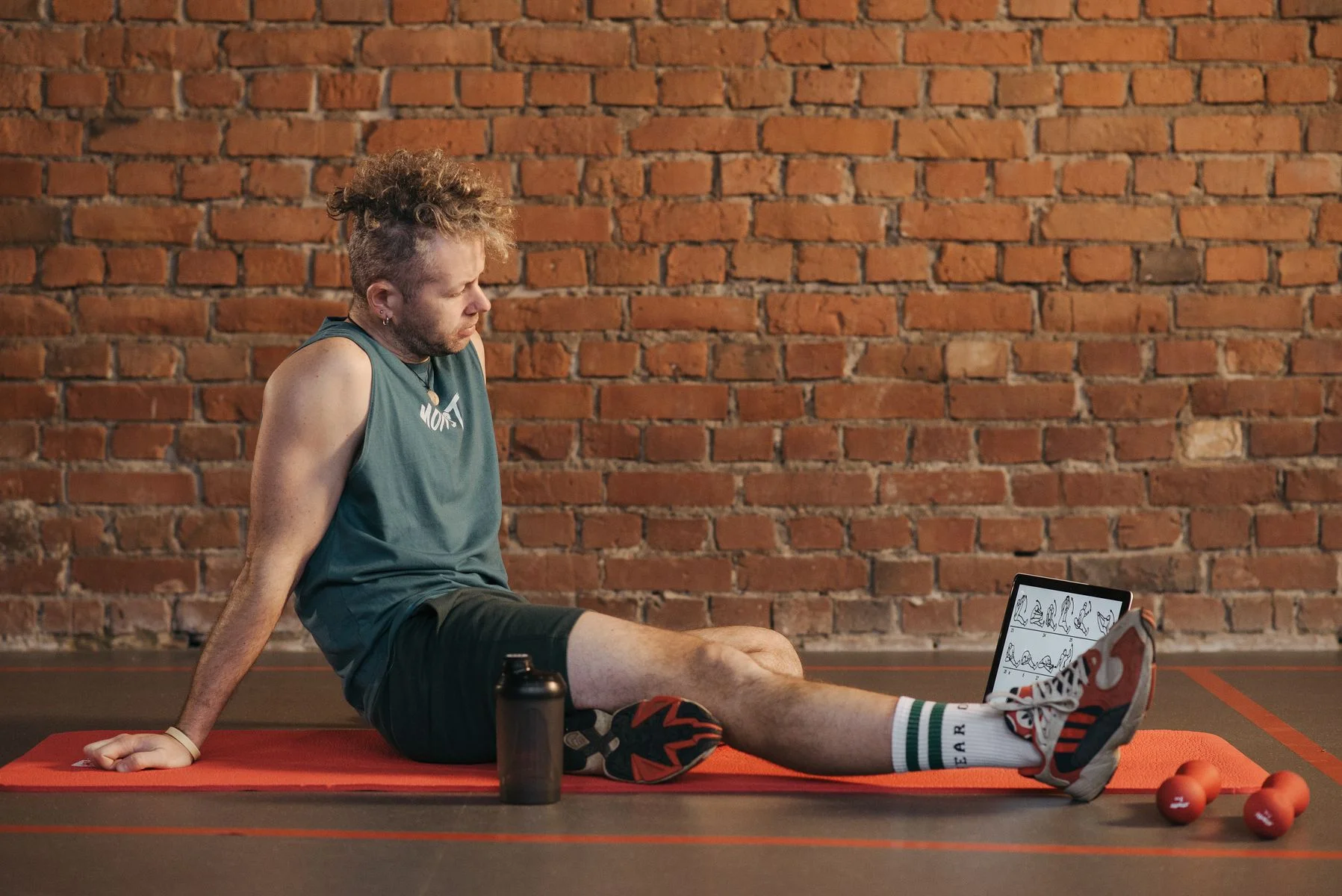 Man resting on a mat in the gym after a workout, illustrating how many rest days a week you actually need for recovery
