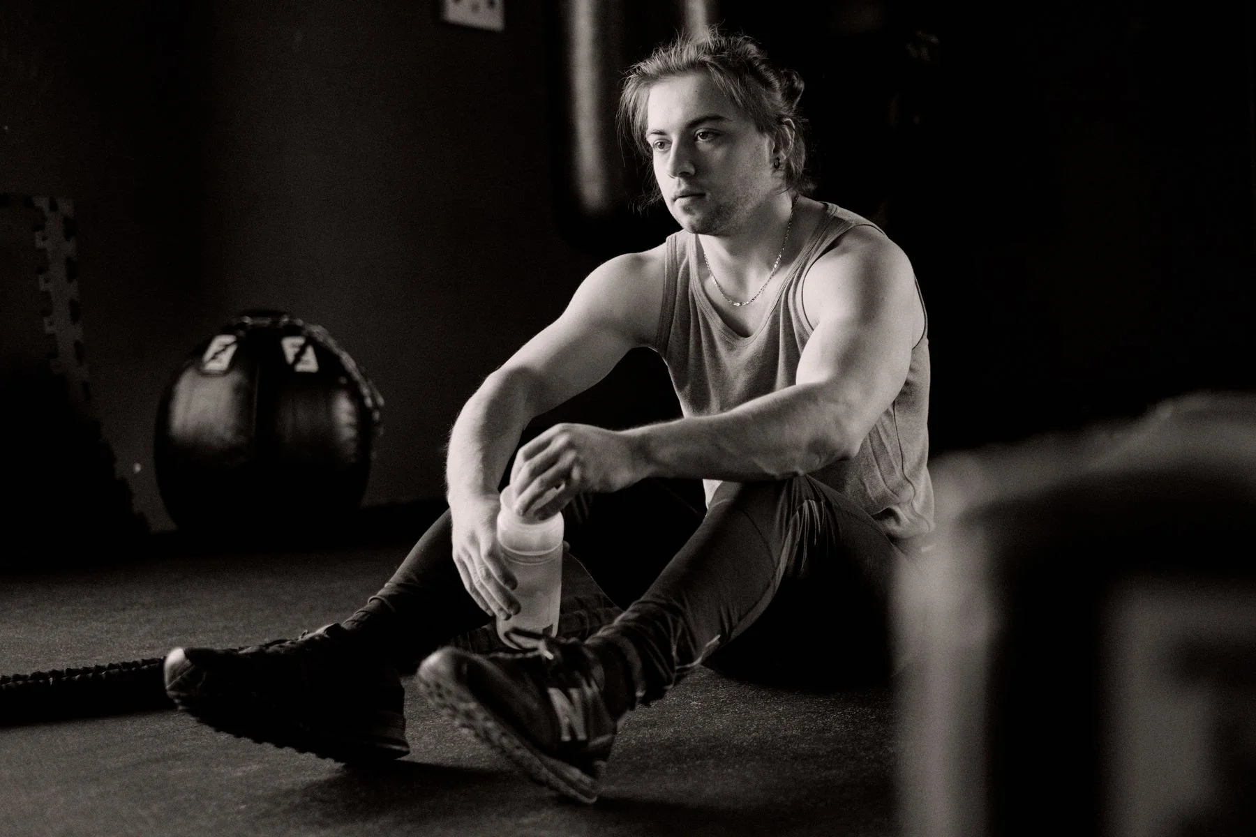 Man resting on a bench in the gym after an intense workout, illustrating signs of overtraining